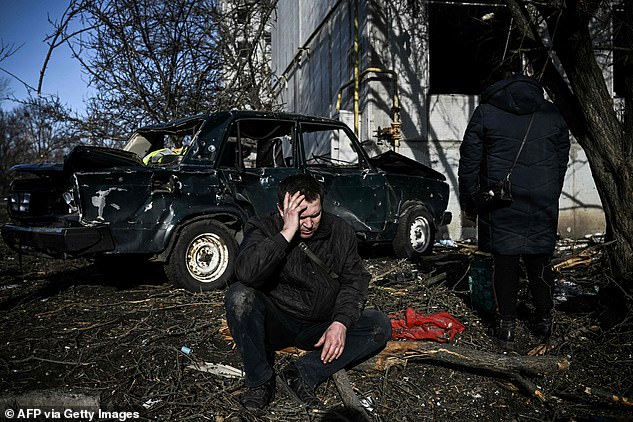 A man sits outside his destroyed building after bombings on the eastern Ukraine town of Chuguiv on February 24, 2022, as Russian armed forces invade Ukraine