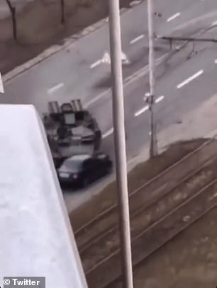 Pictured: A tank shown in the split-second before it crushes a civilian car in the middle of a Kyiv road